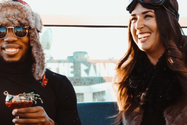 man and woman sitting beside eachother smiling